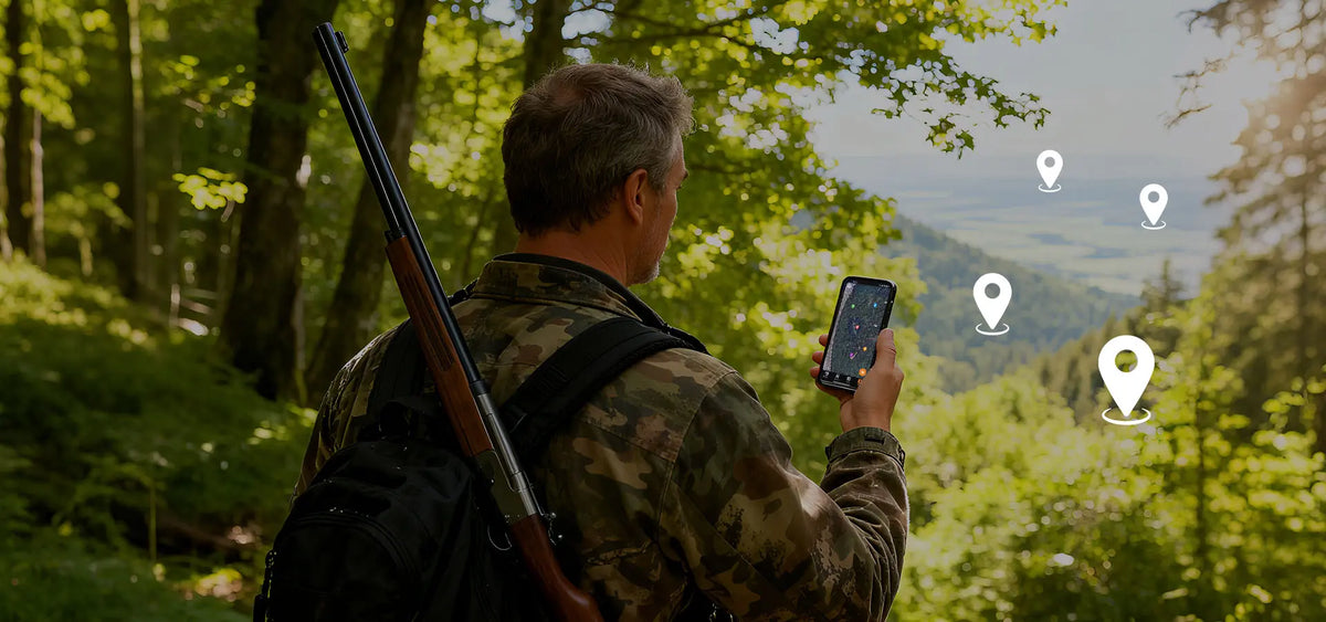 Hunter using a smartphone to locate GardePro E6+ WiFi trail cameras via GPS map tracking in a forest
