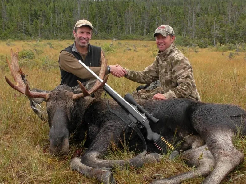 Two hunters with a moose, demonstrating the effectiveness of GardePro X66 Pro cellular trail camera for big-game scouting