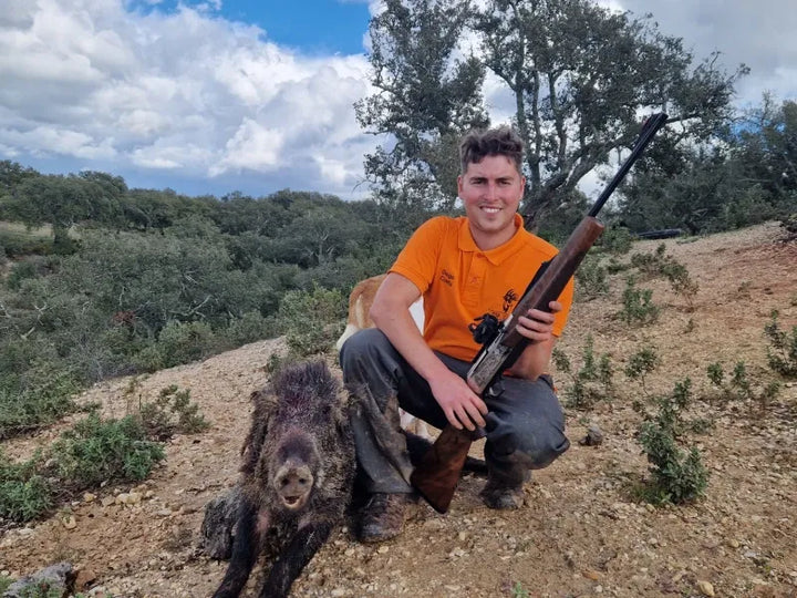 Hunter posing with a wild boar, a result of scouting with the GardePro X66 Pro cellular trail camera