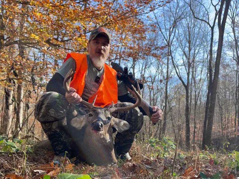 Hunter with a whitetail buck, a successful hunt enabled by data from the GardePro X66 Pro cellular trail camera