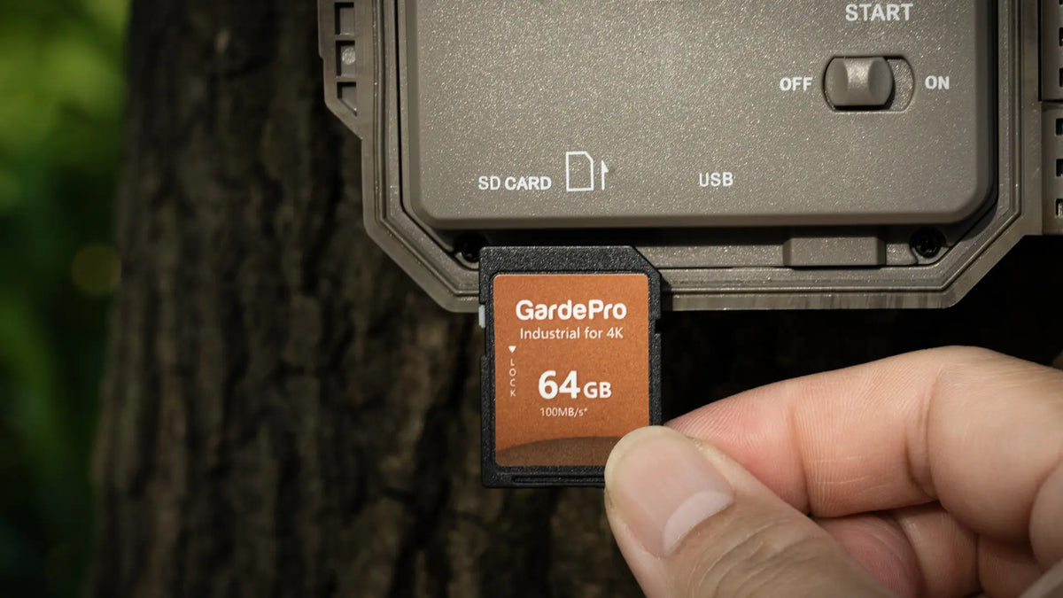 Inserting a 64GB GardePro industrial SD card into a GardePro Link long-range wireless trail camera for 4K video storage